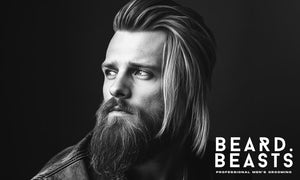 Man with a long hair comb over and full beard, looking to the side, wearing a leather jacket