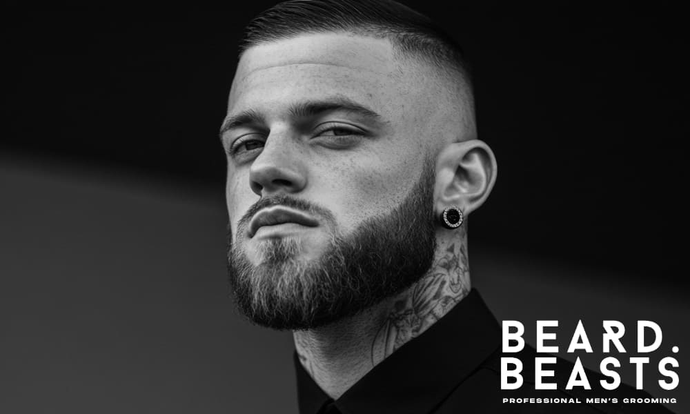 Close-up portrait of a man with a short, well-groomed beard and a defined jawline, showcasing clean and intentional grooming.