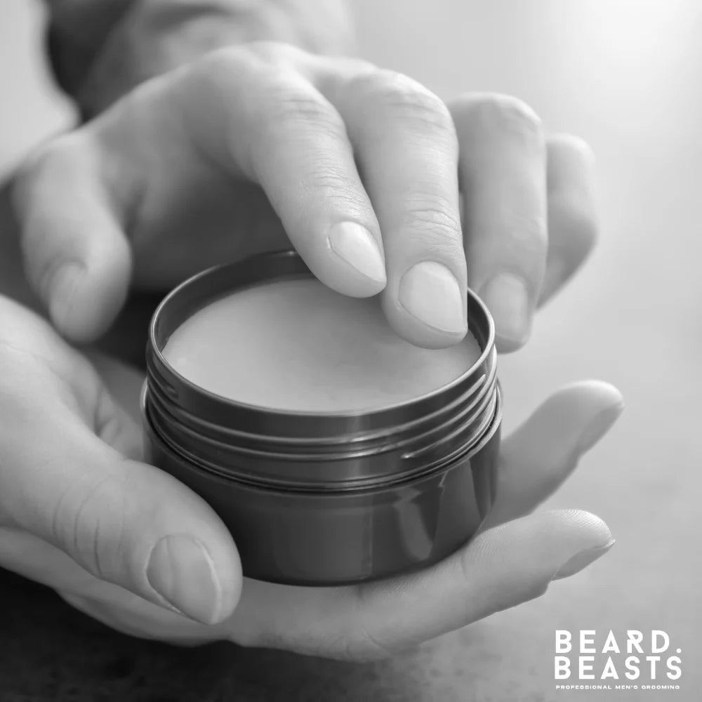 Man scooping beard balm from tin before application to beard