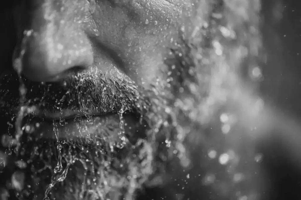 Man washing his beard to avoid common beard grooming mistakes.