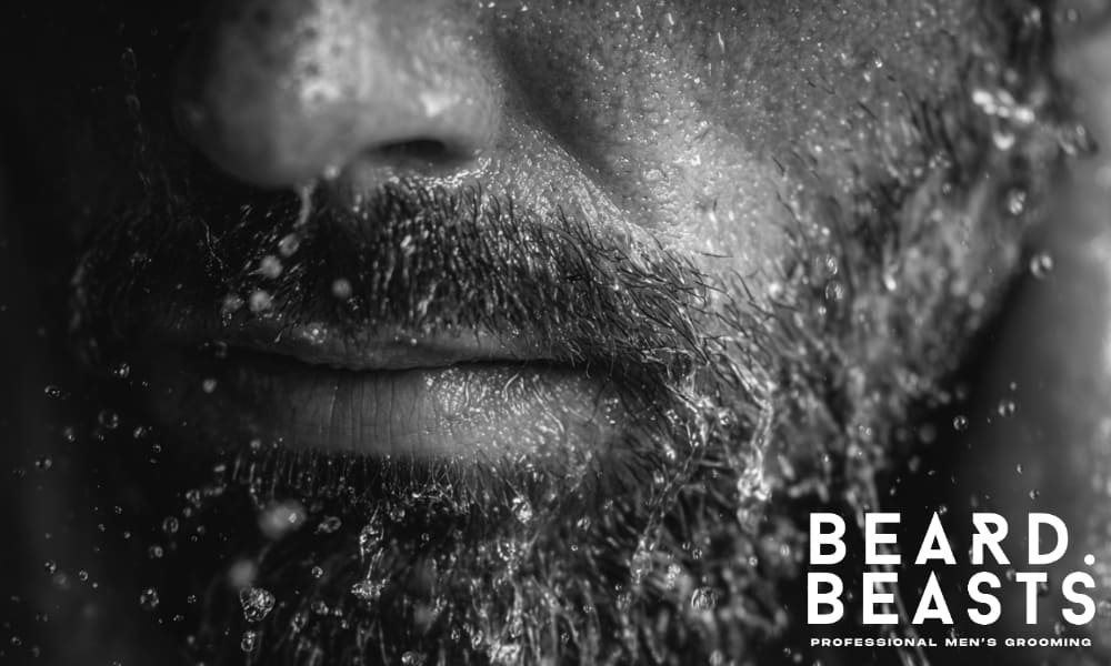 Close-up of a man washing his beard with water, demonstrating the importance of cleansing for a softer beard.
