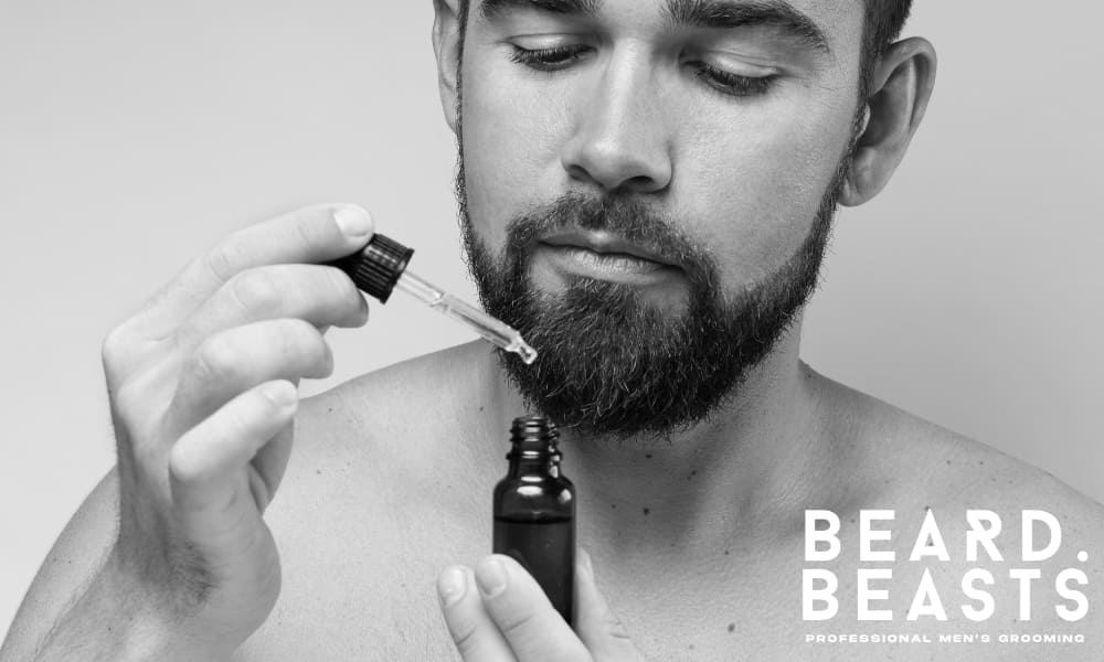 Close-up of a man applying beard oil, demonstrating the proper technique for moisturizing and softening your beard.