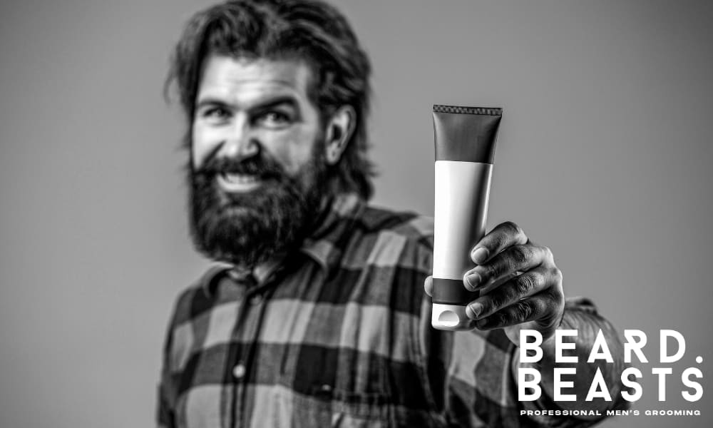 Man holding a bottle of beard conditioner, demonstrating the importance of using a conditioner regularly for a softer and healthier beard.