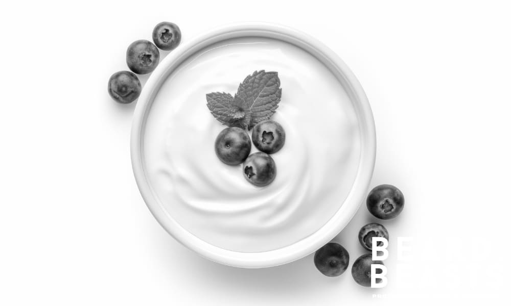 Bowl of Greek yogurt topped with blueberries and mint—rich in protein, B vitamins, and probiotics to support beard growth.