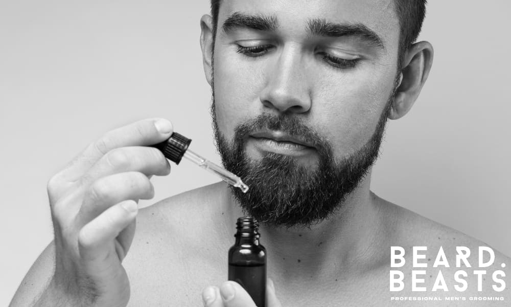 Man applying beard oil with dropper, showcasing how to take care of a beard.