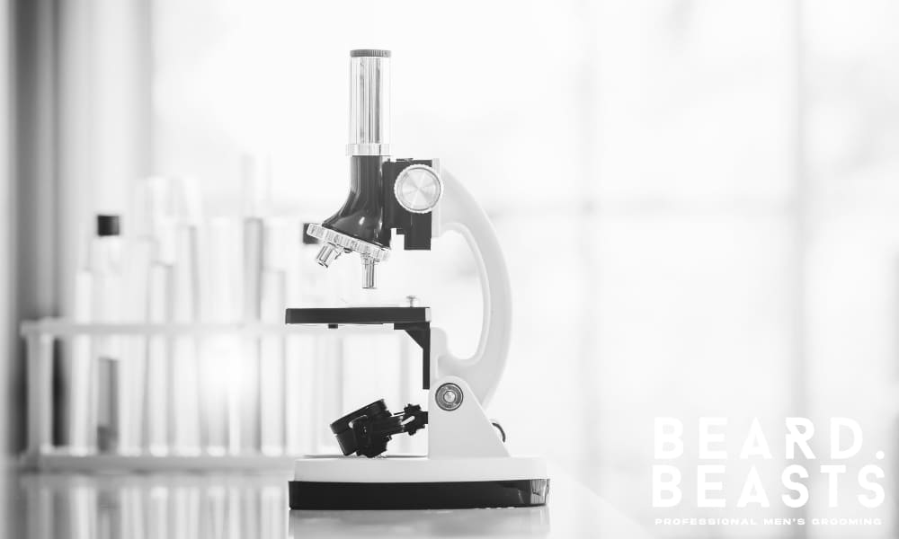Microscope on a lab bench with colorful test tubes, symbolizing the scientific research behind biotin and hair health claims.