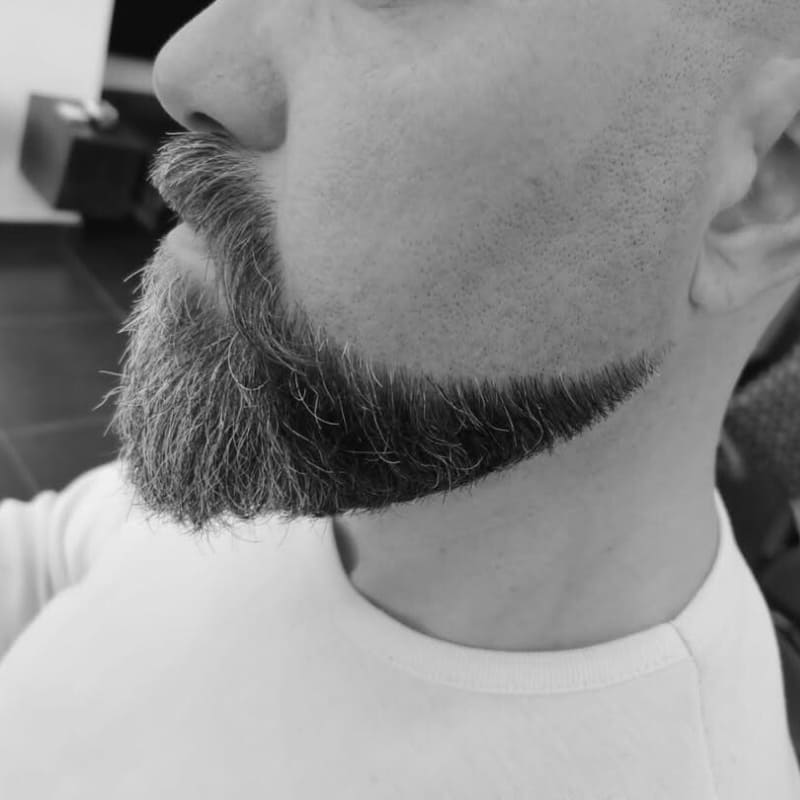 Close-up of a classic Balbo beard with a disconnected mustache, clean-shaven cheeks, and a sharply contoured chin and jawline, styled for a bold, structured look.