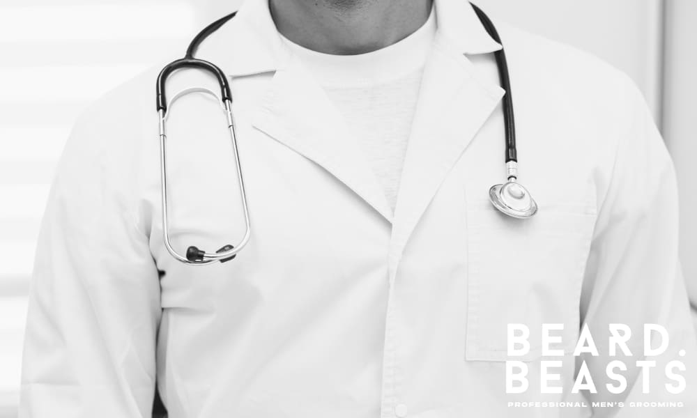 Close-up of a male doctor in a white coat with a stethoscope—reminder to consult a physician before starting biotin supplements.