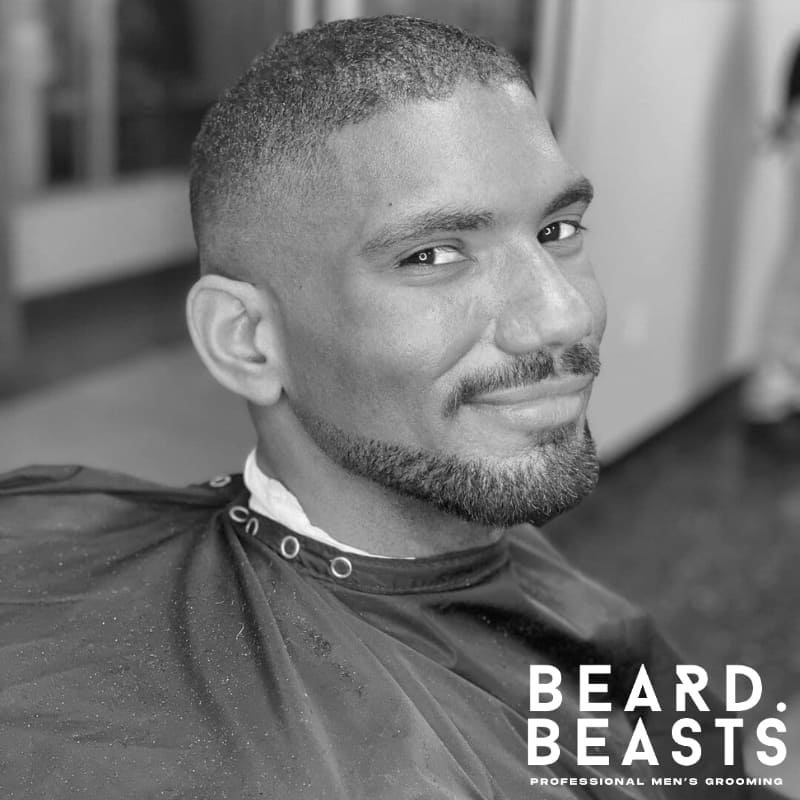 Man with a faded Balbo beard featuring a disconnected mustache, clean cheeks, and sharp jawline definition, paired with a low skin fade haircut.