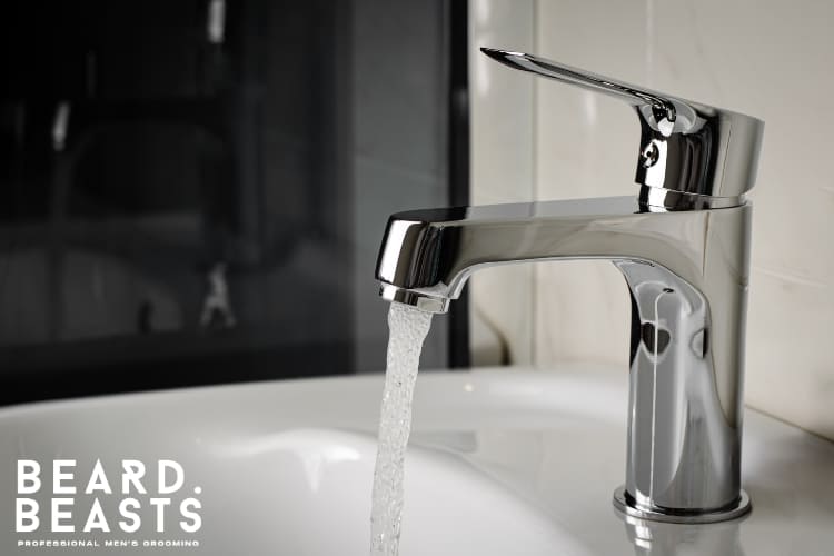 Close-up image of a running faucet representing hard water