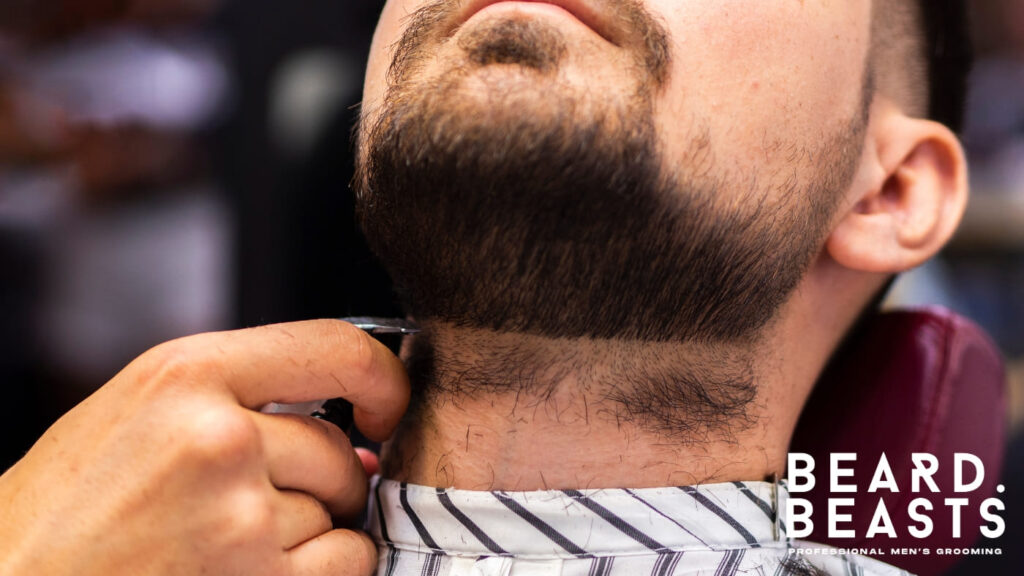 Close-up of a barber trimming a man's neckline with precision. The image highlights the importance of maintaining a clean and defined neckline for a polished and professional beard style.