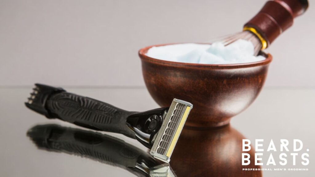 Close-up of shaving equipment, including a razor and a wooden bowl filled with shaving cream, accompanied by a brush.