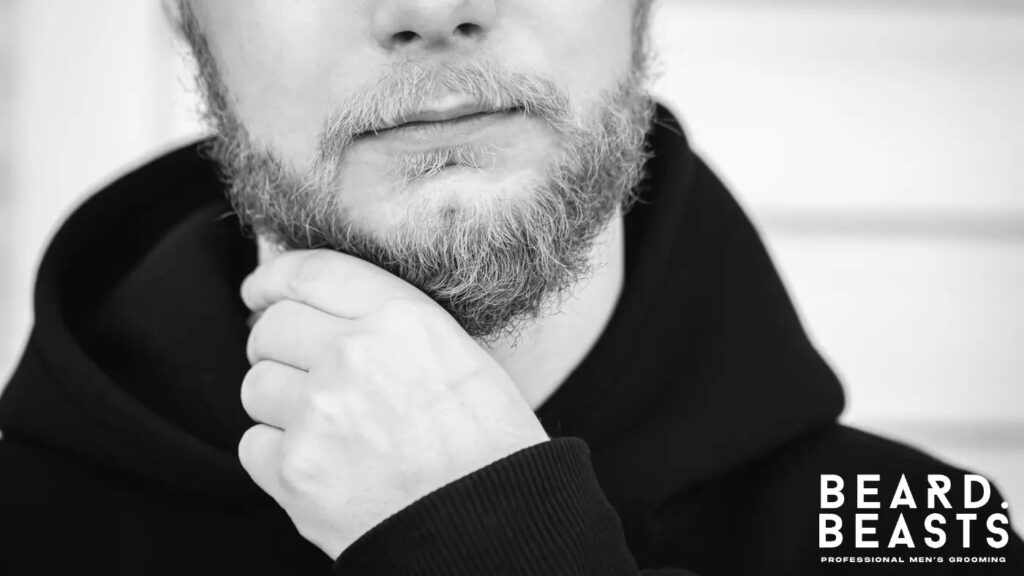 Man touching his dry, brittle beard showing signs of needing beard oil