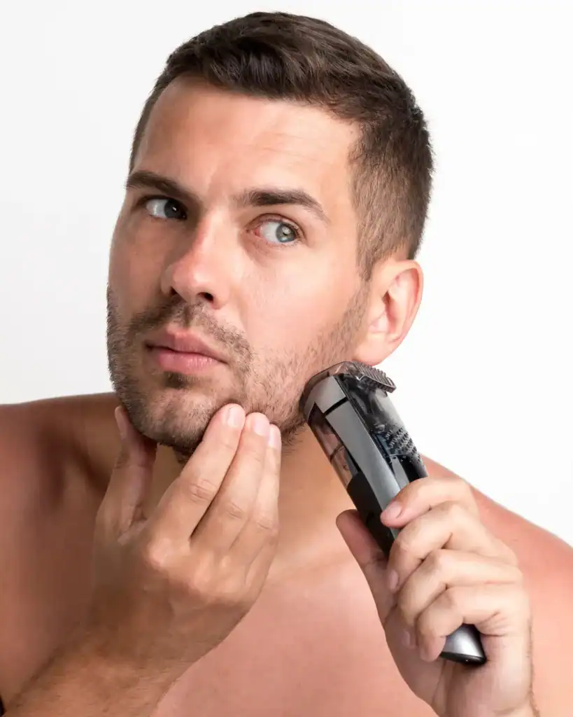 Man trimming a 6mm beard with an electric beard trimmer to maintain a short beard length