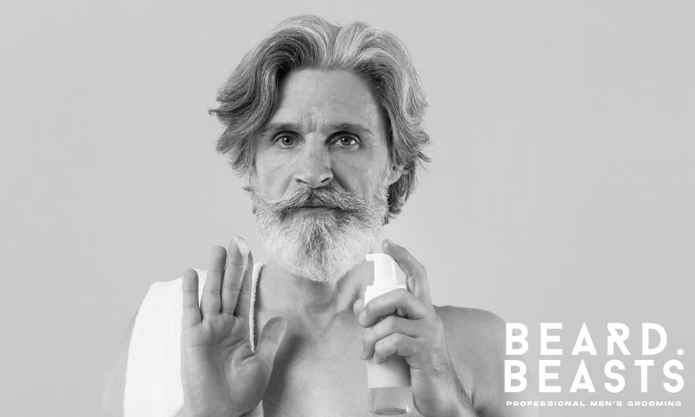 Man applying beard conditioner to hydrate and soften facial hair, supporting beard maintenance and preventing dryness and breakage.