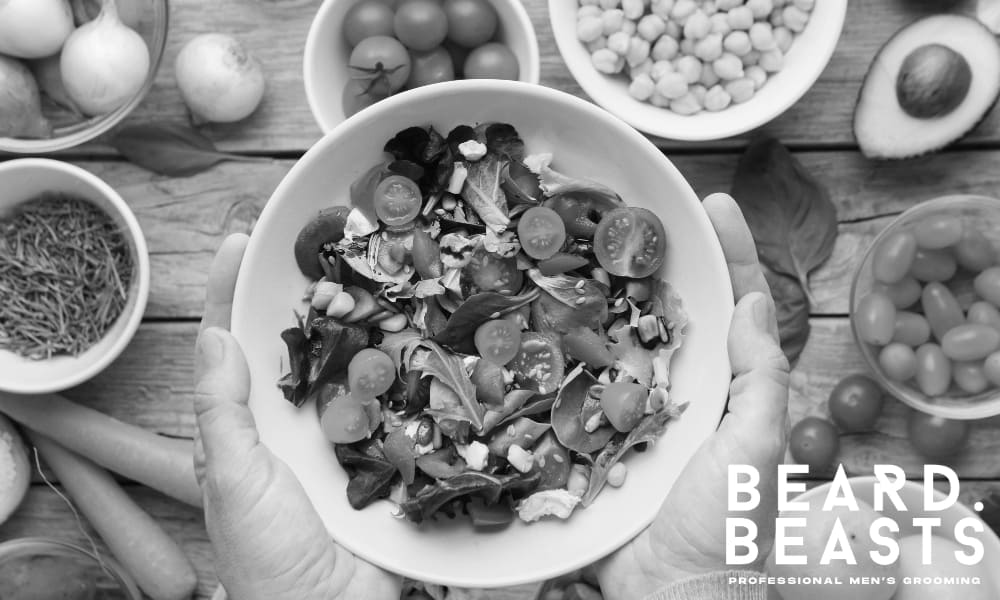 Top view of a colorful salad and whole foods rich in vitamins and nutrients that support beard growth, strength, and maintenance from within.