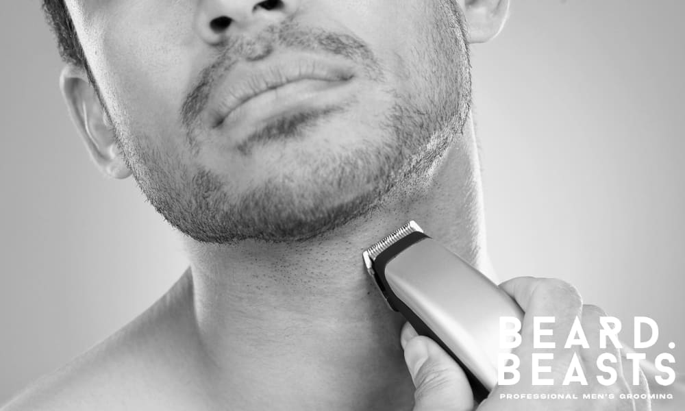 Man trimming his beard to achieve the perfect 4mm beard with an electric trimmer.