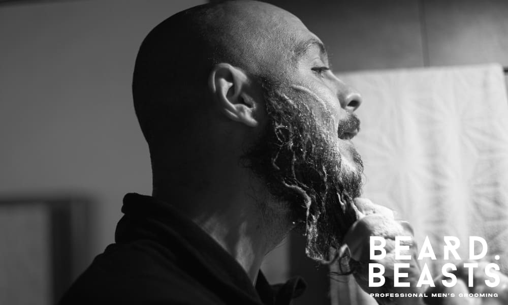 Man washing his beard with foaming cleanser as part of a beard maintenance routine, emphasizing skin health and proper beard wash technique.