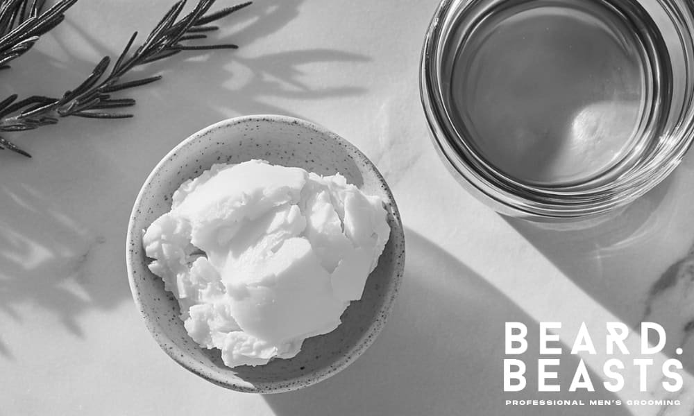 Natural shea butter and golden oil on marble surface—core ingredients that support beard health and growth