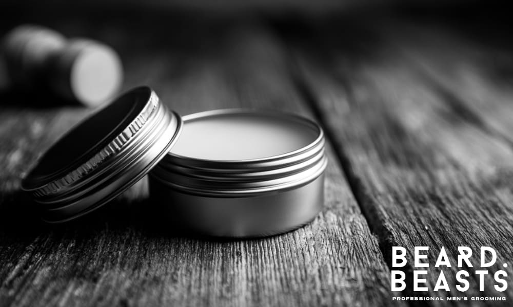 homemade beard balm in a metal tin on rustic wooden background