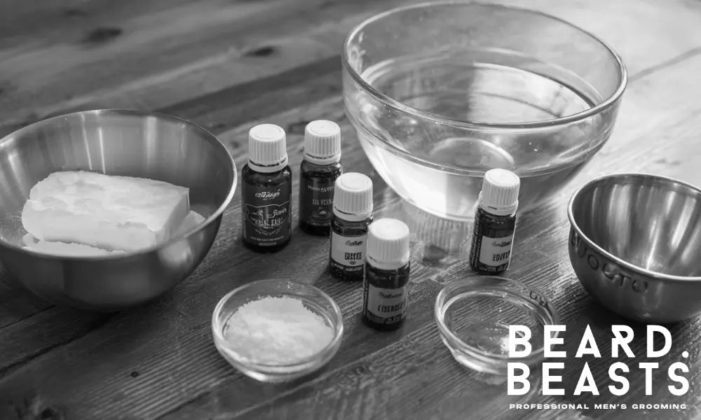 Essential ingredients for homemade beard wash, including castile soap, essential oils, and water, set on a wooden table ready for mixing.