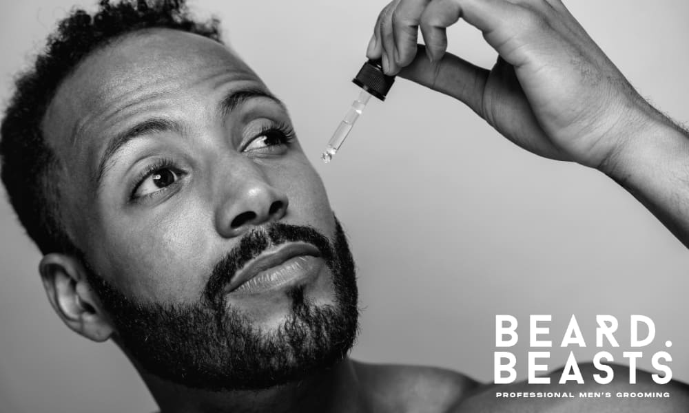 Close-up of man applying beard oil to moisturize skin and support beard growth