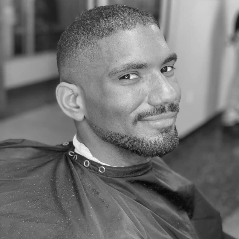 Man with a sharp Balbo beard style featuring clean cheek lines and a faded haircut—perfect example of a modern goatee-inspired beard for men.