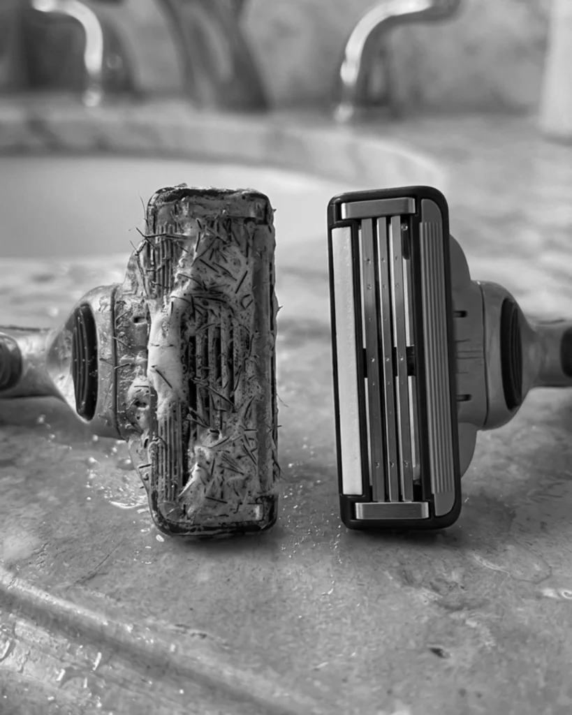 Clogged razor cartridge beside a clean replacement blade showing how buildup can cause dragging and razor burn on the neck