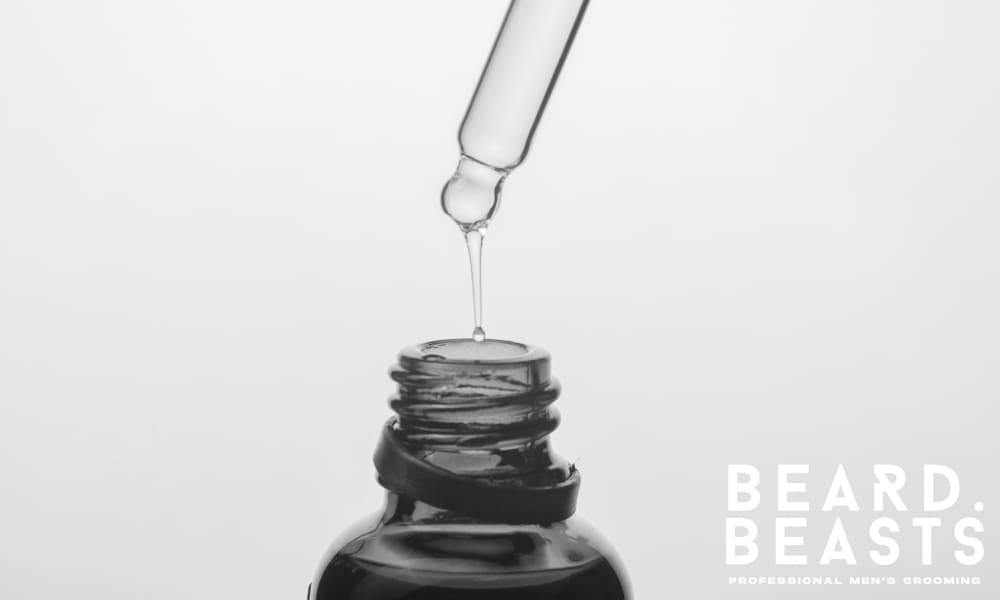 Close-up of a dropper releasing eucalyptus oil into an amber bottle—illustrating how to properly use eucalyptus oil for beard care