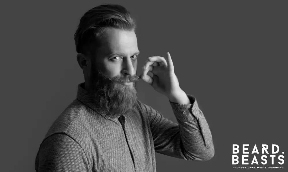Man with a red beard and styled mustache demonstrating the importance of grooming techniques for maintaining a well-kept beard.