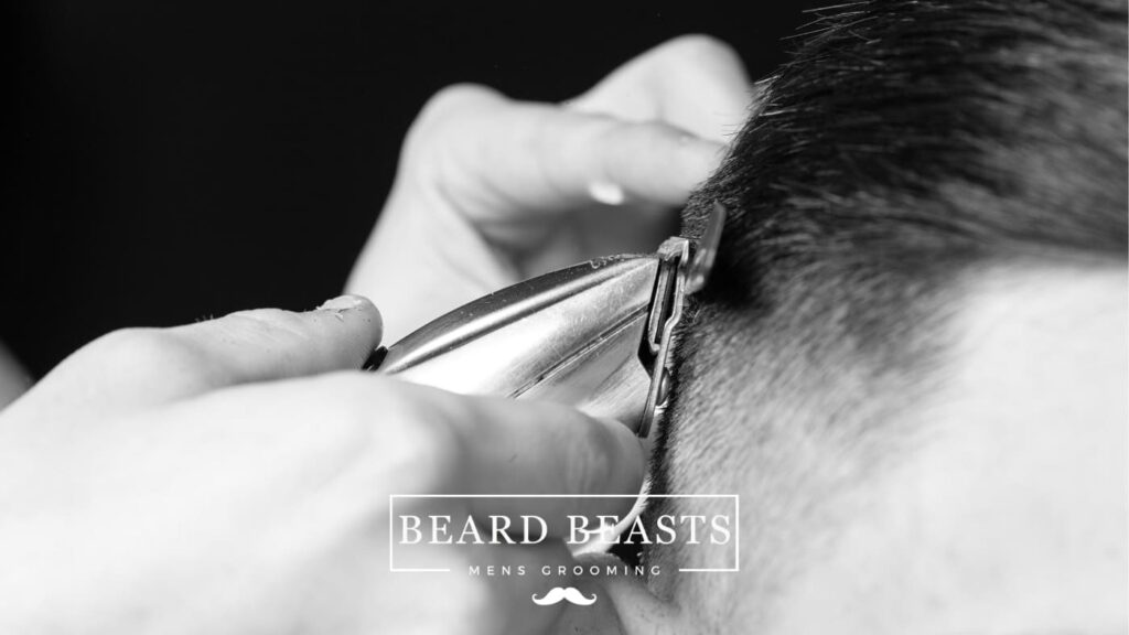Close-up view of a barber using clippers to create a taper fade haircut, demonstrating the technique after a client has learned how to ask for a taper fade.