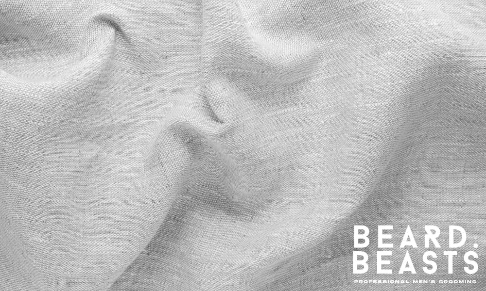 Close-up texture of natural linen fabric, highlighting its breathable weave and soft drape—used to illustrate how fabric affects fit and comfort.