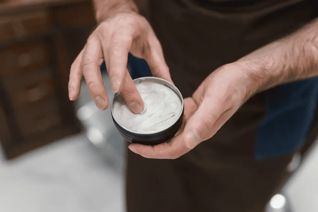 Close-up of men’s hair clay in an open jar showing thick matte texture