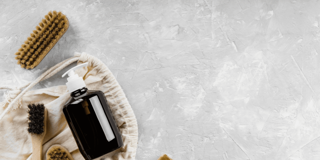 Essential tools for cleaning hair clippers: blade oil, stiff-bristle brush, and cleaning solution.