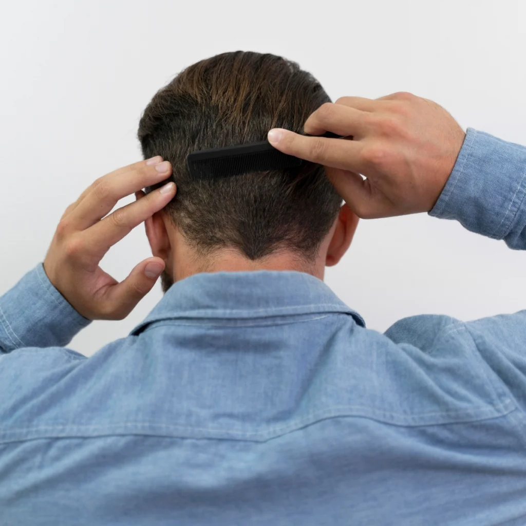 Man combing short styled hair with a black comb