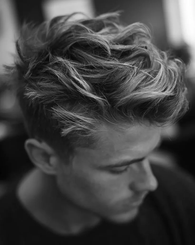 Close-up of textured men’s hair, showing how hair type and natural movement affect whether a pompadour or quiff works better.