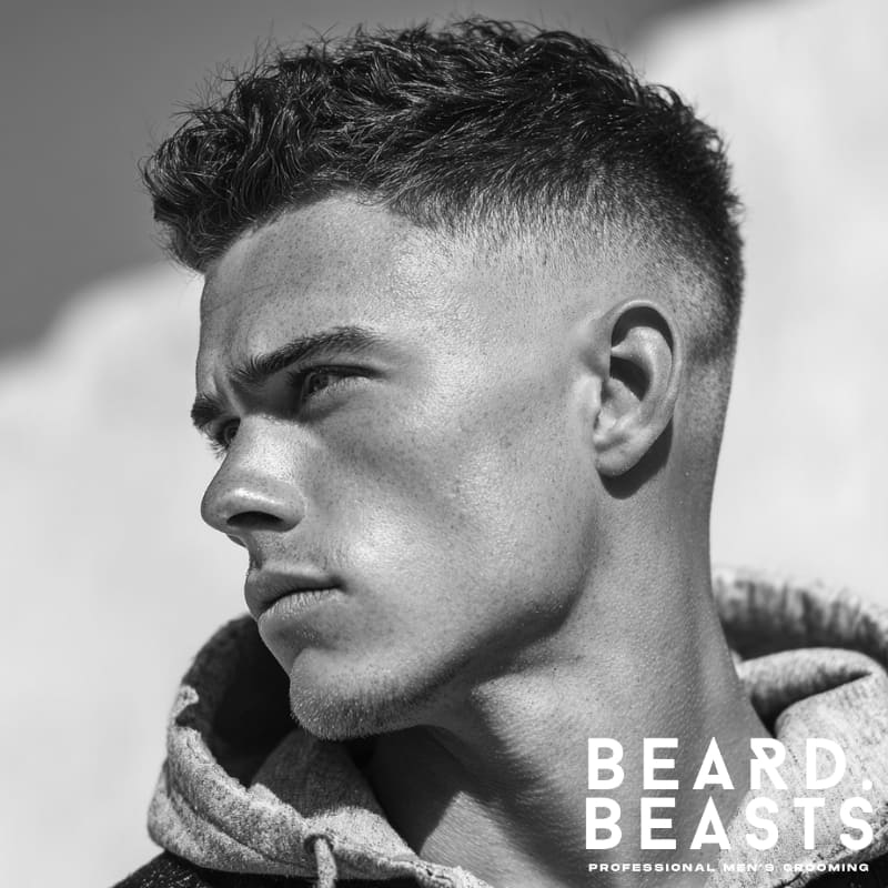 Man with a textured top and bald fade haircut, side profile showcasing sharp fade and natural texture.