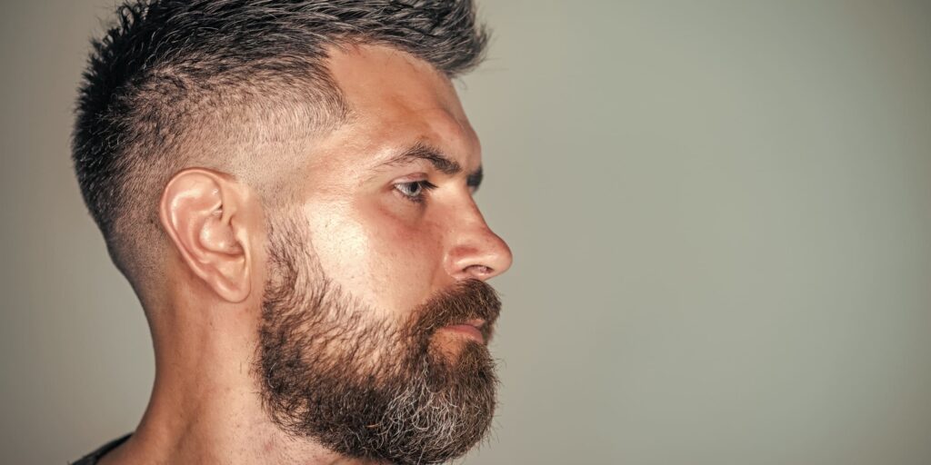 Side profile of a man with a high fade haircut, illustrating the fade vs taper differences.