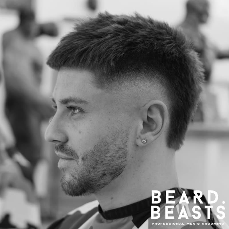 Men's burst fade haircut with a sharp contrast between the faded sides and textured top, offering a dynamic and bold look. Ideal for those seeking a unique and stylish fade.