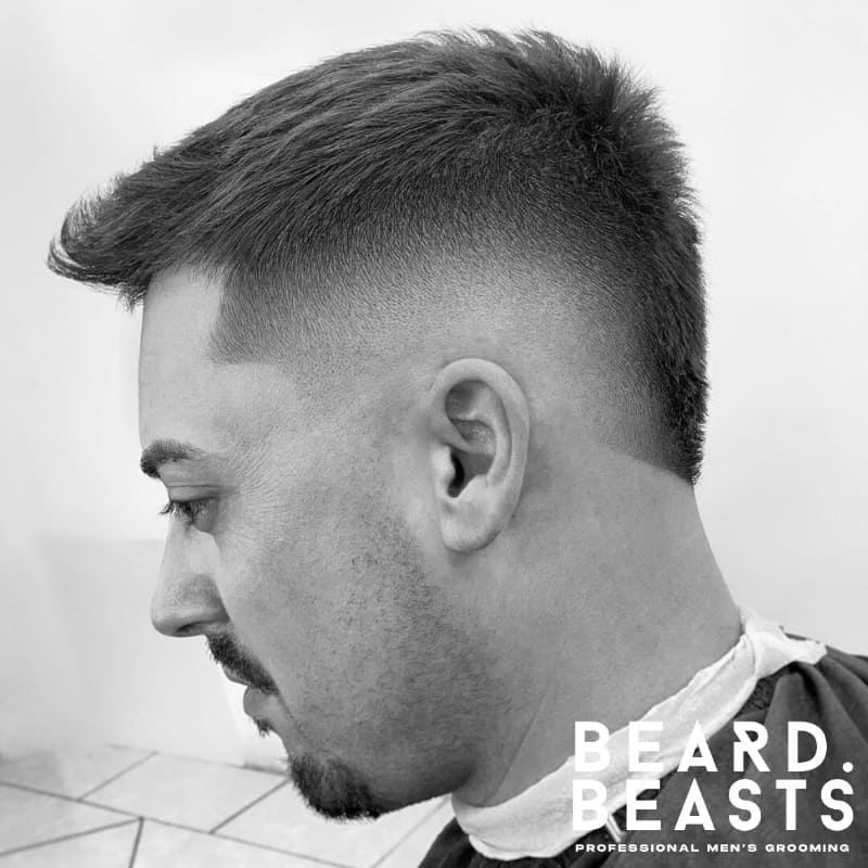 Men's Mohawk fade featuring sharp fade sides with voluminous spiked hair on top. Ideal for a bold, statement-making style with a strong contrast.