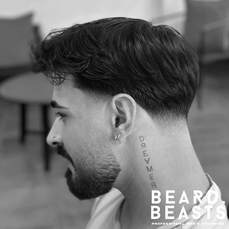Men's taper fade haircut with textured quiff on top and clean fade on the sides, offering a sharp, sleek style. Ideal for a polished yet effortless look.