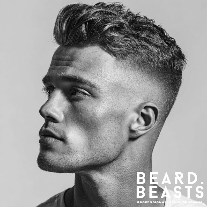 Man with a short fade haircut and voluminous quiff, side profile showcasing sharp styling.