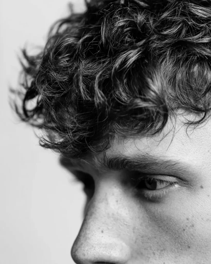 Close-up of curly men’s hair, showing why hair type can affect whether a burst fade or drop fade works better.
