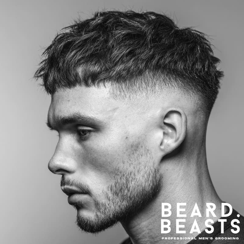 A professional image of a man with a high drop fade haircut, featuring textured hair on top and a smooth, curved fade down to the back, creating a modern, sharp look.