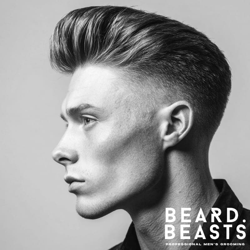 A profile of a man with a high fade and pompadour, featuring voluminous hair on top and a clean, sharp fade on the sides for a polished and sophisticated look.