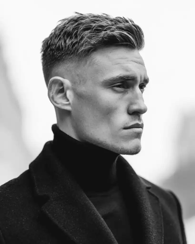High fade haircut for men with straight hair, featuring short faded sides and textured length on top