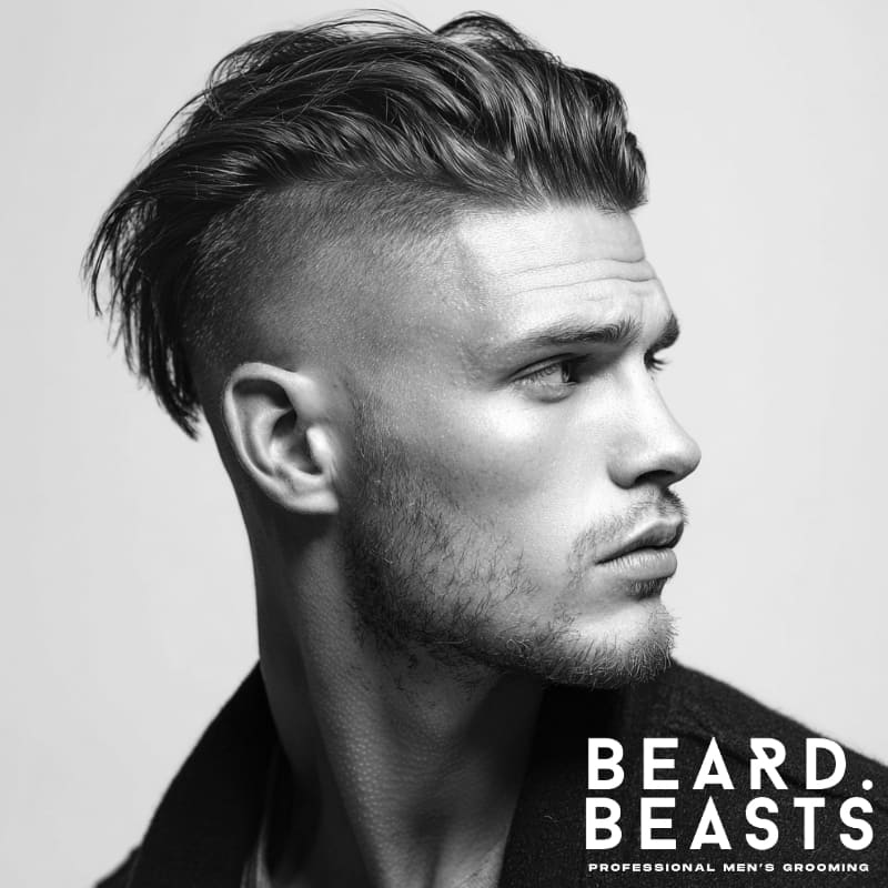 A side profile of a man with a high fade undercut, featuring longer hair on top contrasted with faded sides, creating a bold and edgy look.