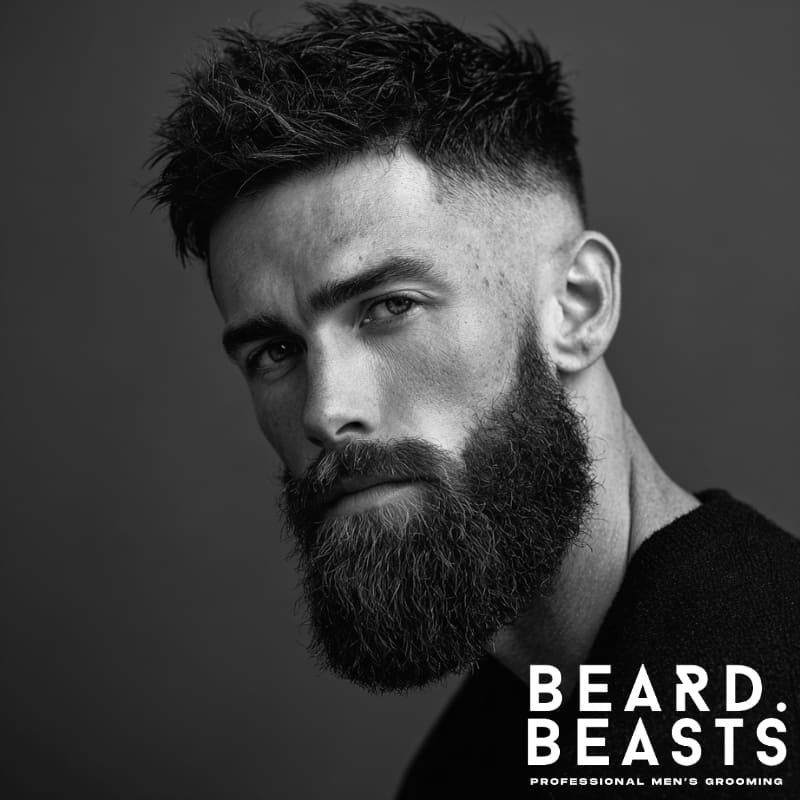 A side profile of a man with a high fade and full beard, showcasing a bold contrast between the clean fade on the sides and the full beard for a strong, masculine look.
