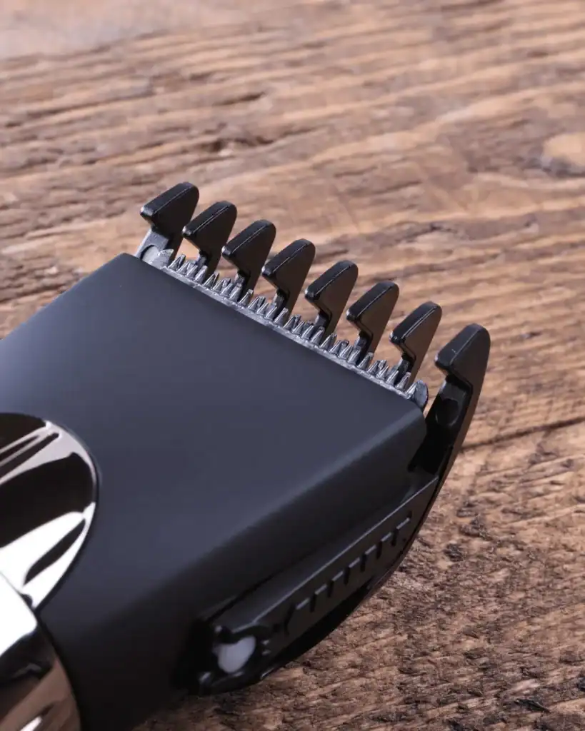 Close up of hair clipper blades with a plastic guard attachment for a number 1 buzz cut