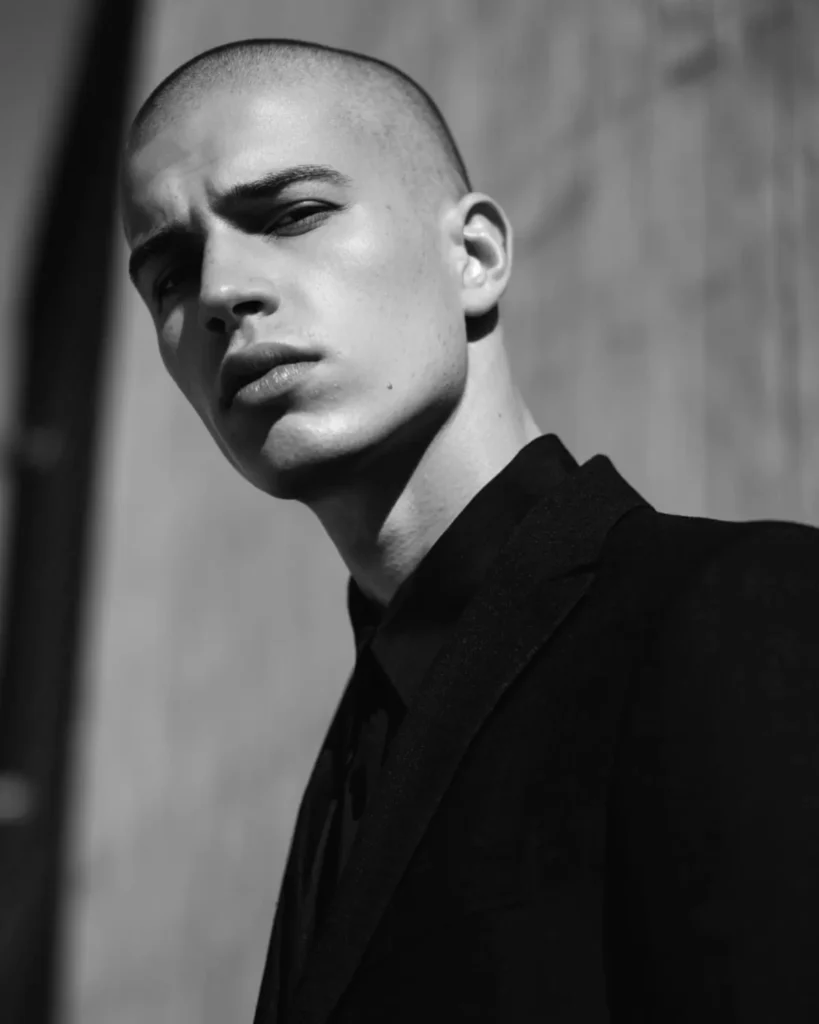Number 1 buzz cut on a clean-shaven man with exposed scalp, close-cropped hair, and strong facial structure